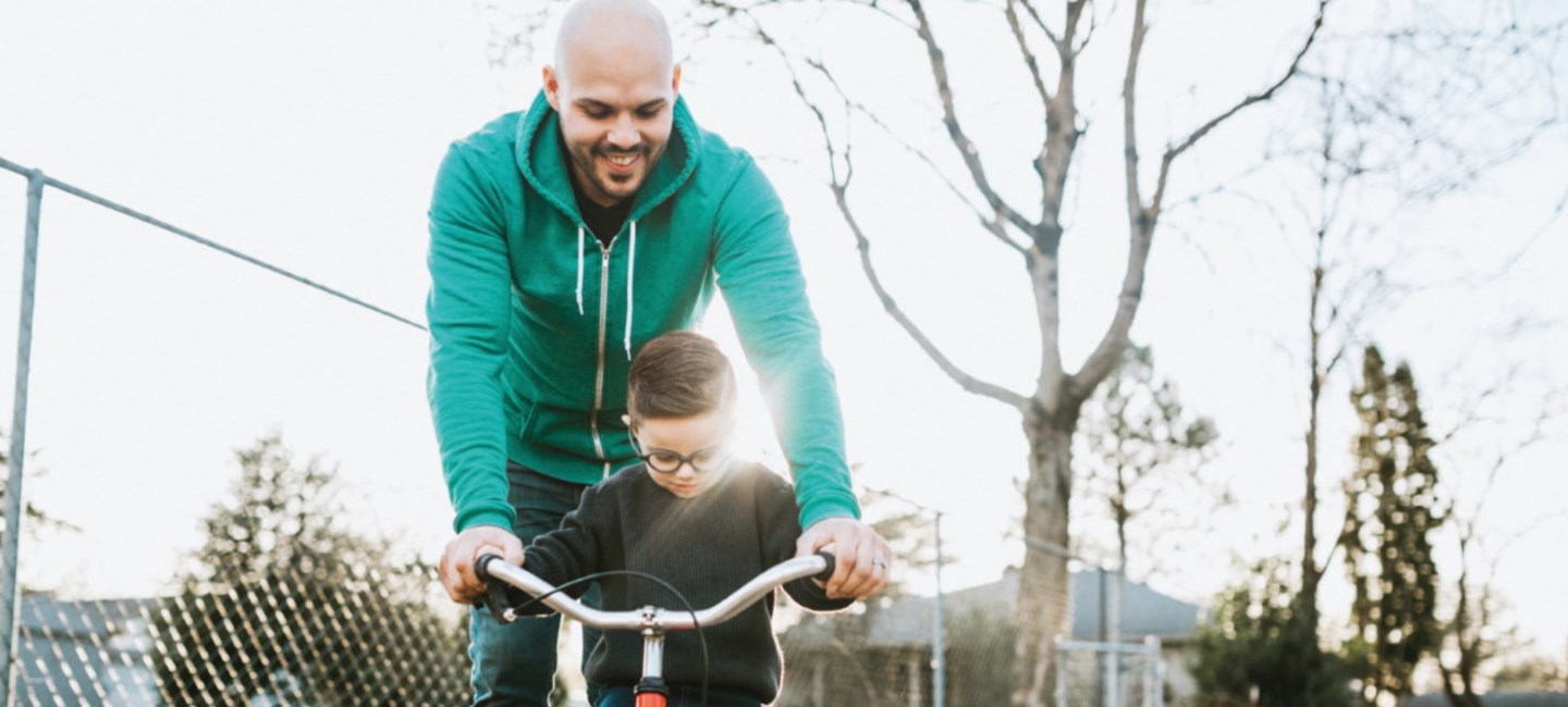 Father teaching a son how to ride a bicycle