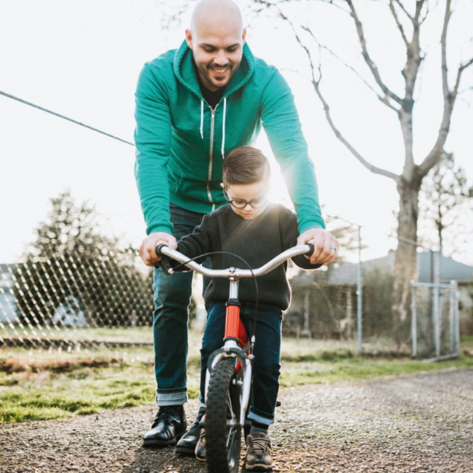 Father teaching a son how to ride a bicycle